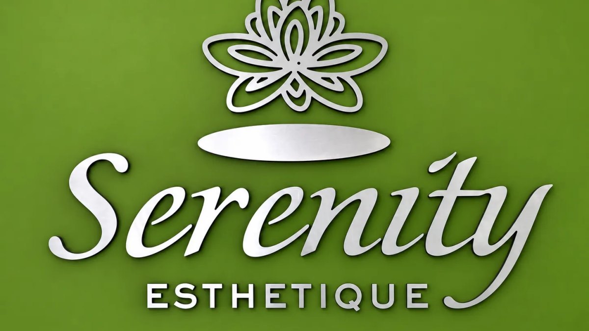 Serenity Esthetique logo in raised silver on a green wall