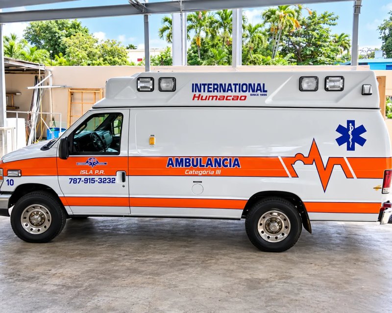 Ambulancia de International Humacao rotulada con franja naranja y estrella de la vida